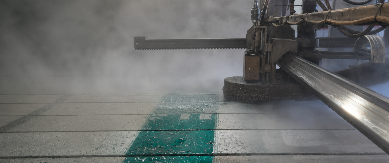 Hydrostripping machine removing reflective sheeting from an aluminum highway sign using high-pressure water, with steam rising during the recycling process.