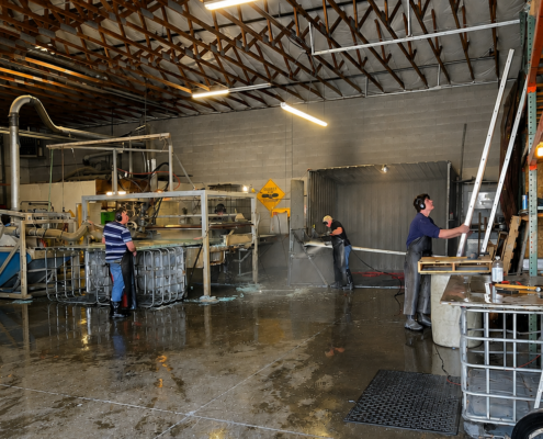 Hydrostripping Operations at Northwest Sign Recycling Employees processing aluminum traffic signs inside the Northwest Sign Recycling facility during hydrostripping and sign refurbishment operations.