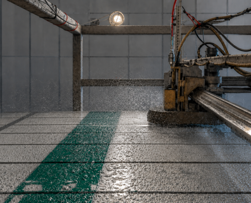 The hydrostripping process in action at Northwest Sign Recycling, where high-pressure water removes reflective sheeting from aluminum traffic sign material for recycling and reuse.